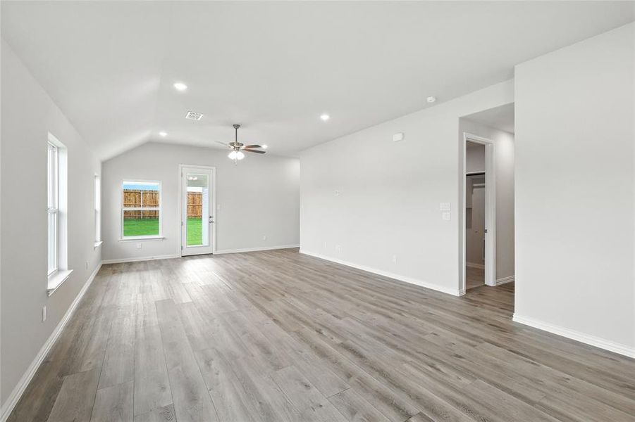 Unfurnished living room with ceiling fan, vaulted ceiling, wood finished floors, and recessed lighting