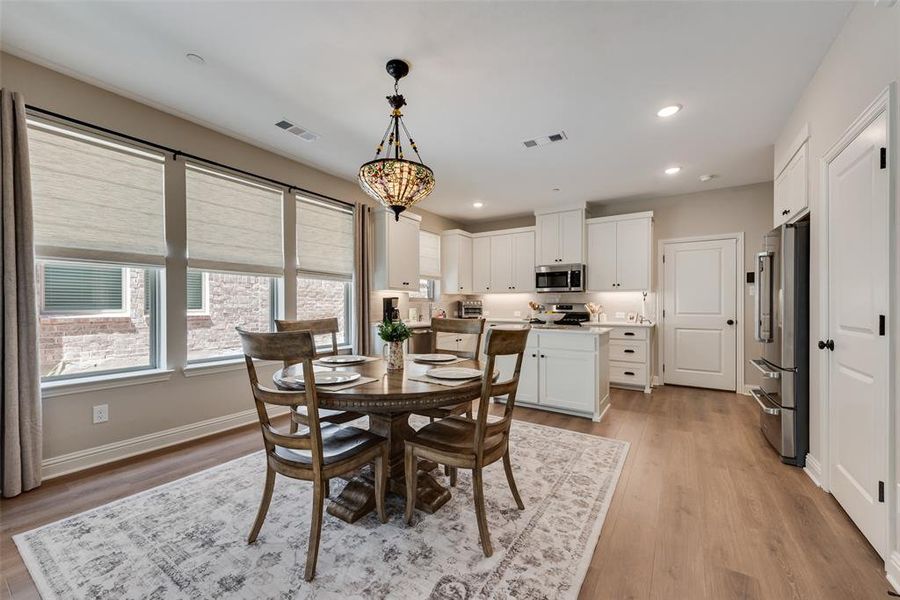 Dining room with light wood-style flooring and recessed lighting
