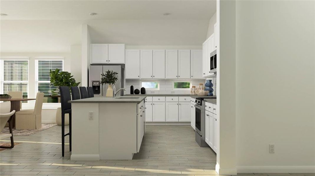 Kitchen featuring stainless steel appliances, backsplash, a kitchen breakfast bar, and white cabinetry Kitchen featuring stainless steel appliances, backsplash, a kitchen breakfast bar, and white cabinetry