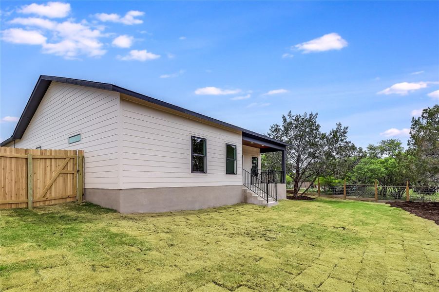 View of property exterior with fence and a yard
