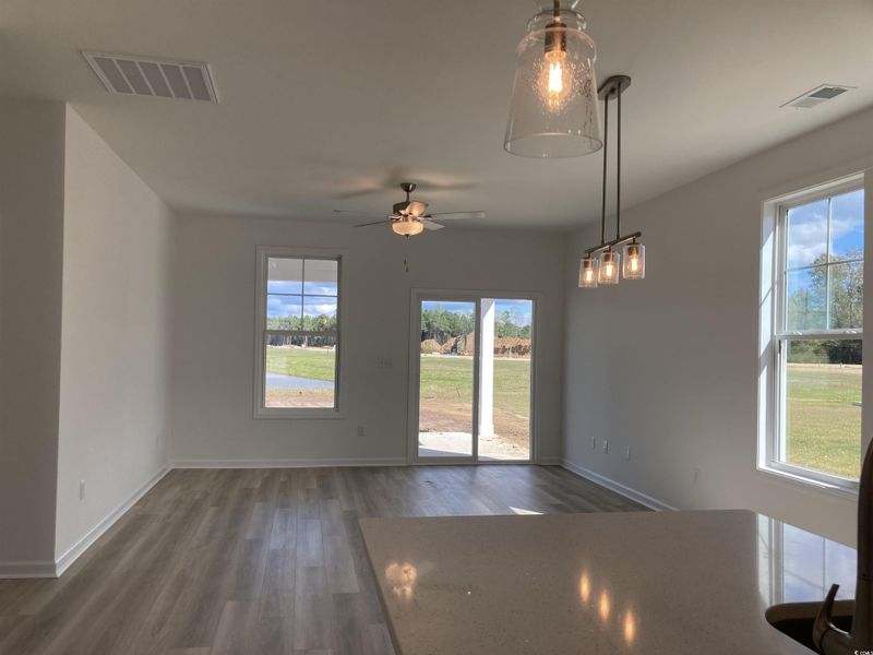 Unfurnished dining area featuring dark wood-style floors and a ceiling fan