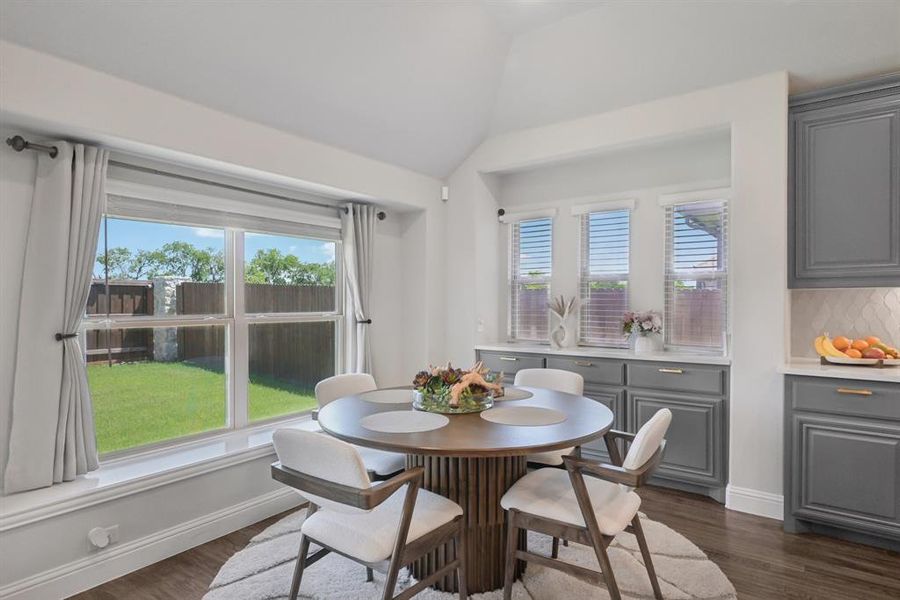 Dining area with plenty of natural light, lofted ceiling, and dark wood-type flooring Dining area with plenty of natural light, lofted ceiling, and dark wood-type flooring