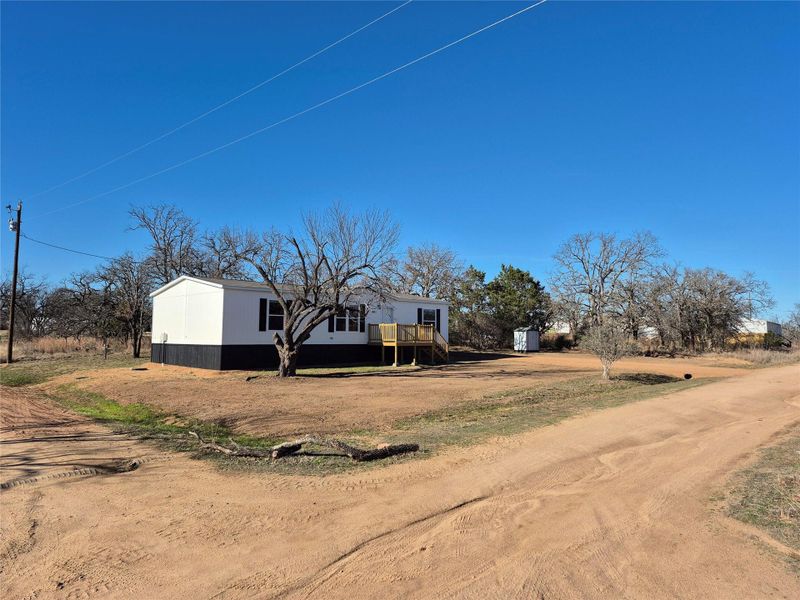 View of front facade featuring driveway and a deck