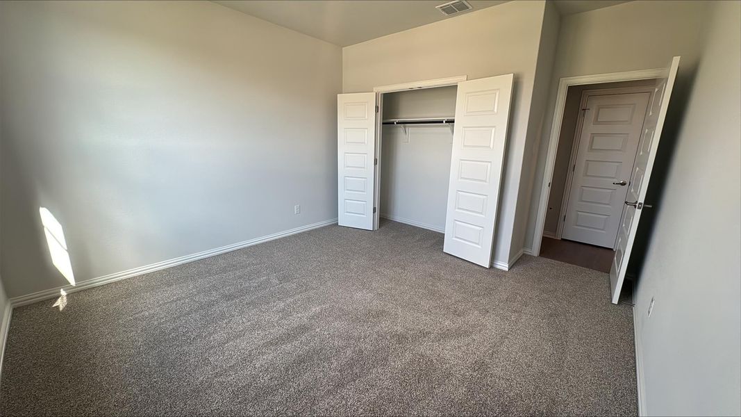 Unfurnished bedroom with carpet and a closet Unfurnished bedroom with carpet and a closet