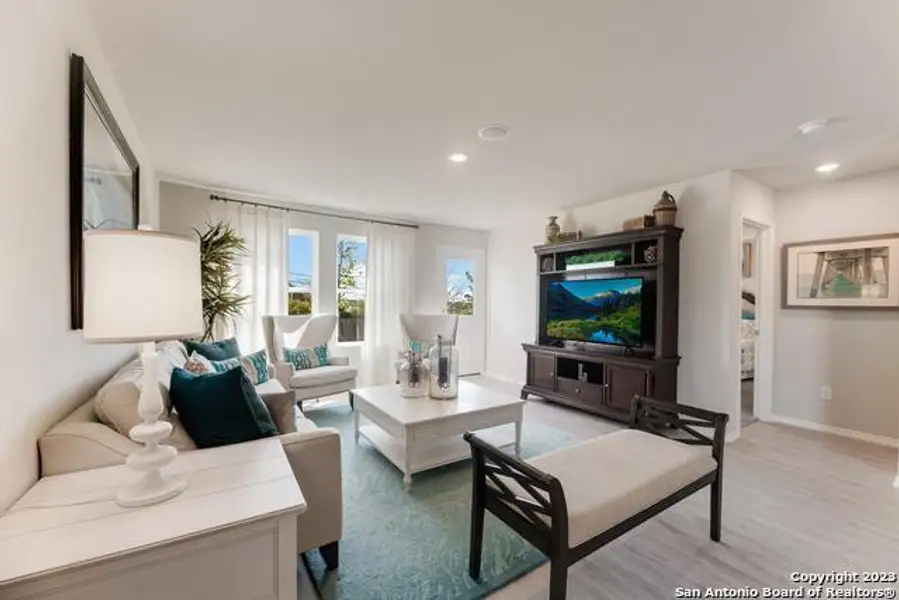 Living area with light wood-style floors and recessed lighting Living area with light wood-style floors and recessed lighting