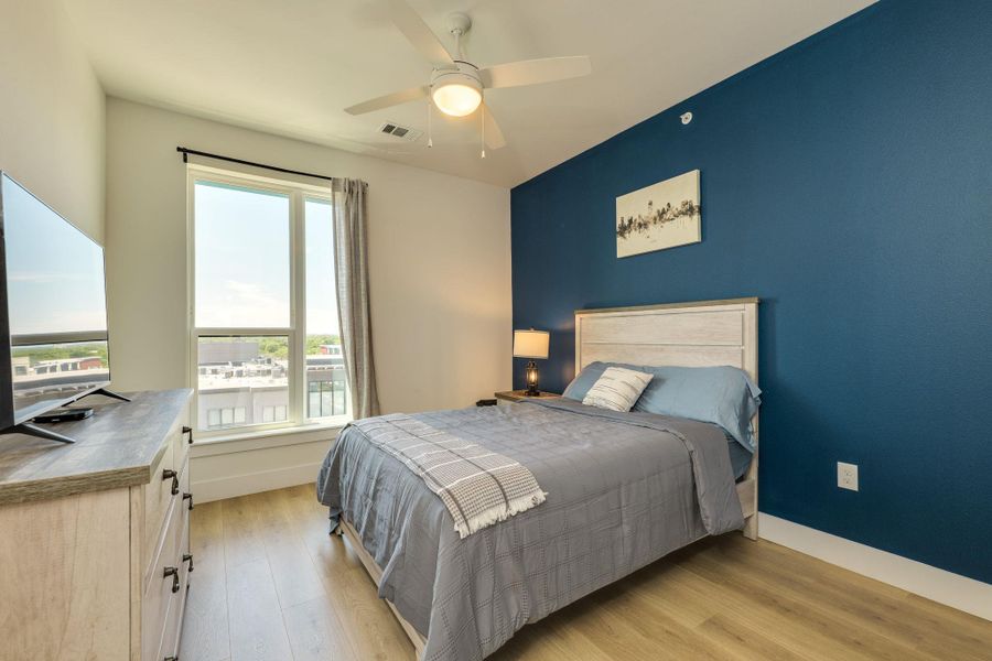 This room features a ceiling fan, a window with a view, and light-toned flooring