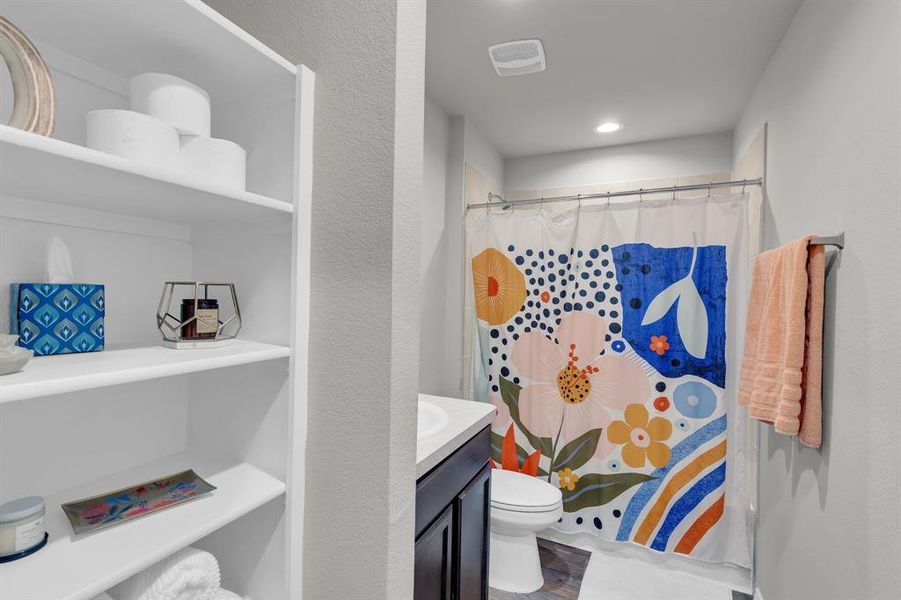 Full bathroom located at the front of the home, nestled between guest bedrooms 1 and 2. This bathroom offers a functional layout with a shower/tub combo, single-sink vanity, and modern fixtures, providing easy access for guests and family.