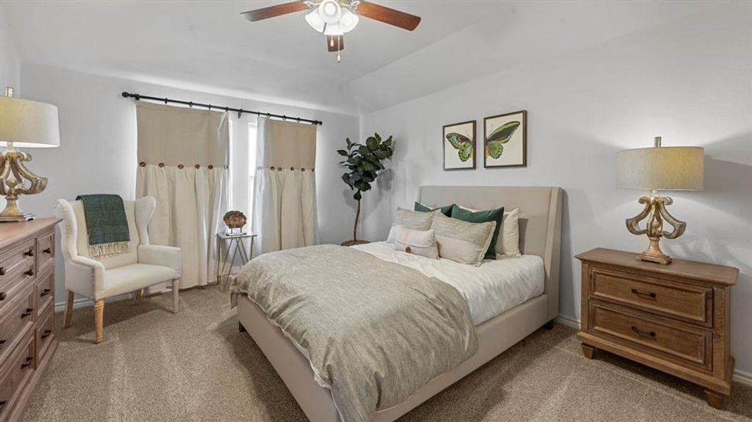 Carpeted bedroom featuring a ceiling fan and lofted ceiling