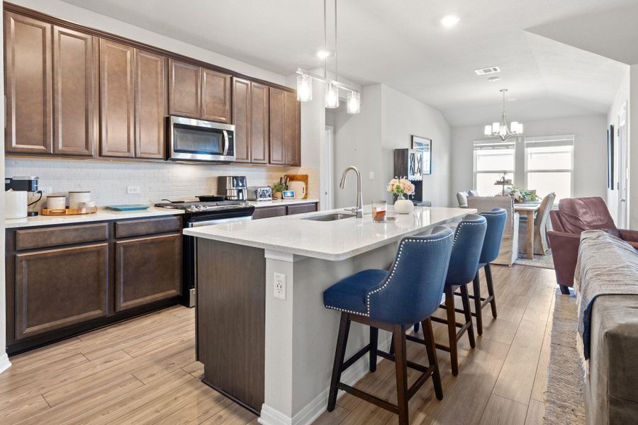 Kitchen with light wood-style flooring, tasteful backsplash, a breakfast bar area, open floor plan, and recessed lighting Kitchen with light wood-style flooring, tasteful backsplash, a breakfast bar area, open floor plan, and recessed lighting