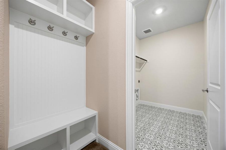 Mudroom featuring baseboards and light floors