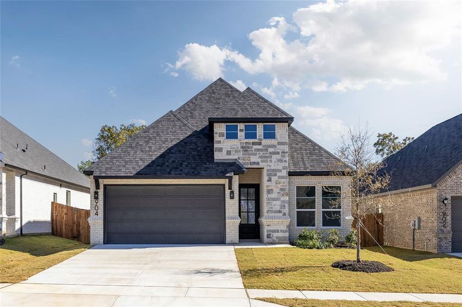 View of front of home featuring brick siding, concrete driveway, a garage, and stone siding