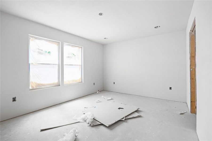 An interior space with white walls and a concrete floor
