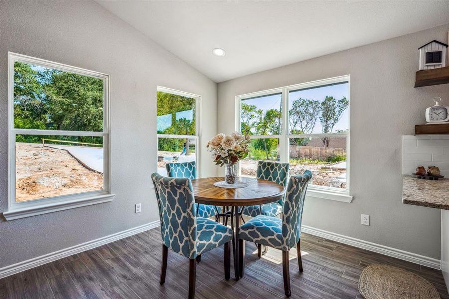 Dining area featuring vaulted ceiling and dark hardwood / wood-style floors