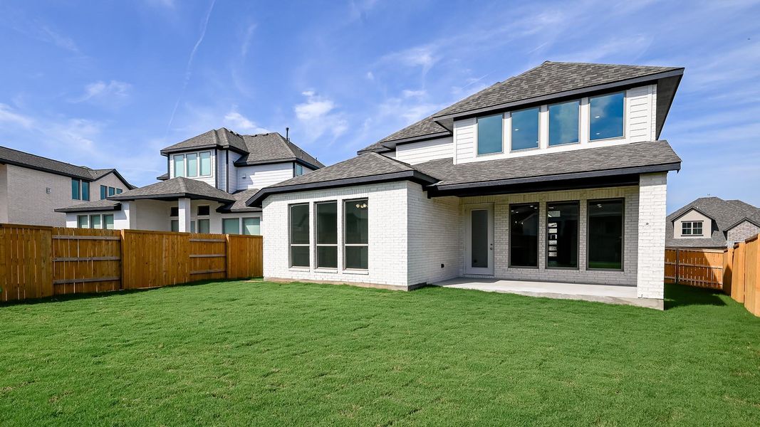 Back of property with a patio area, a fenced backyard, brick siding, and roof with shingles