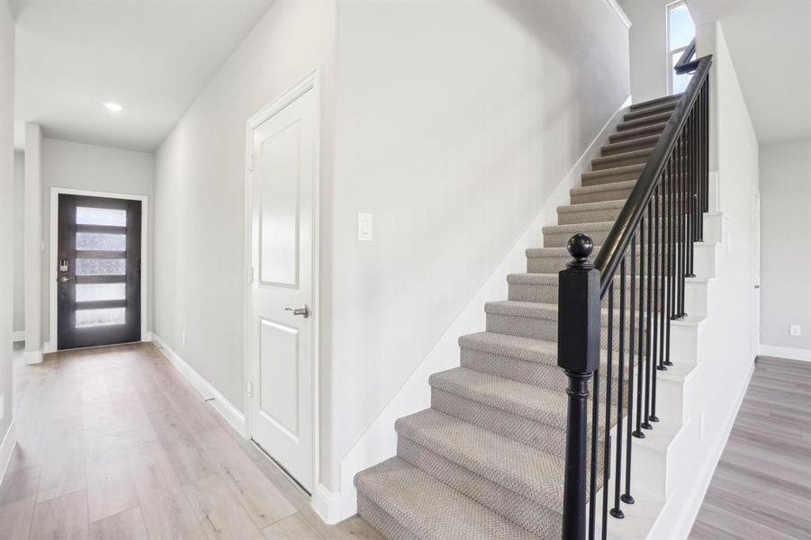 Foyer entrance featuring light wood-type flooring, stairway, and recessed lighting Foyer entrance featuring light wood-type flooring, stairway, and recessed lighting