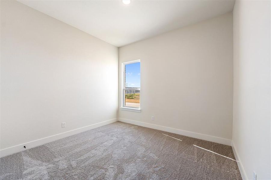 Carpeted empty room featuring baseboards
