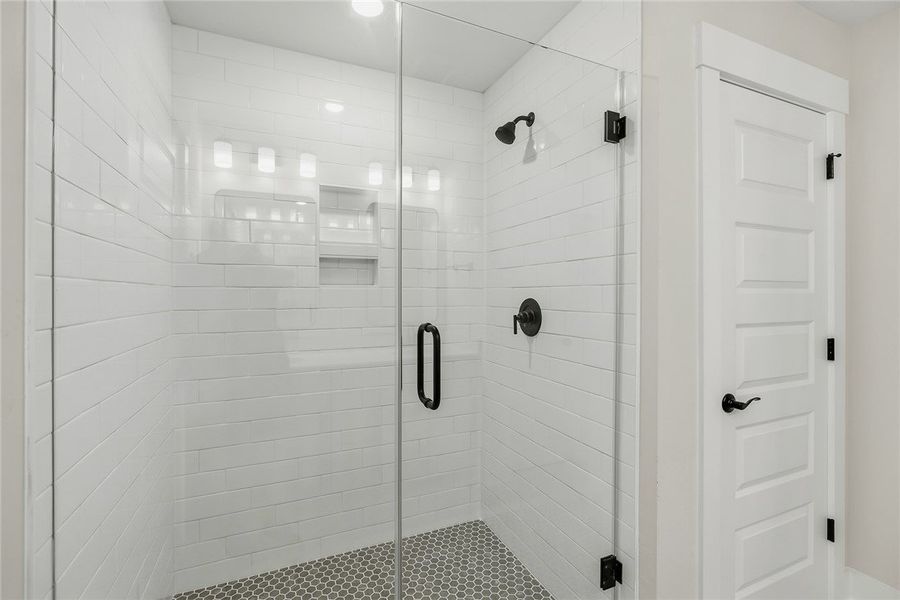 Crisp subway tile surrounds a modern walk-in showe