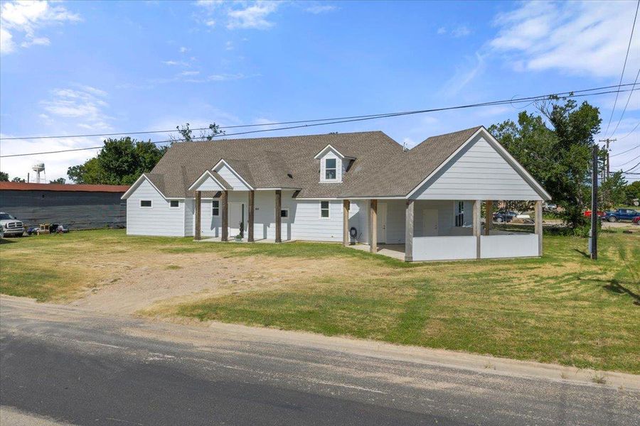 View of front of property featuring roof with shingles, a front yard, driveway, and a porch View of front of property featuring roof with shingles, a front yard, driveway, and a porch