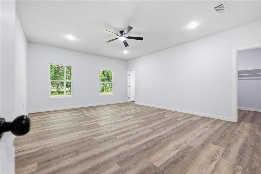 Generously sized primary bedroom retreat complete with a ceiling fan, recessed lighting, and large windows. Generously sized primary bedroom retreat complete with a ceiling fan, recessed lighting, and large windows.