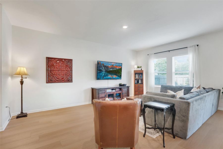 Living area featuring light wood-style flooring and recessed lighting