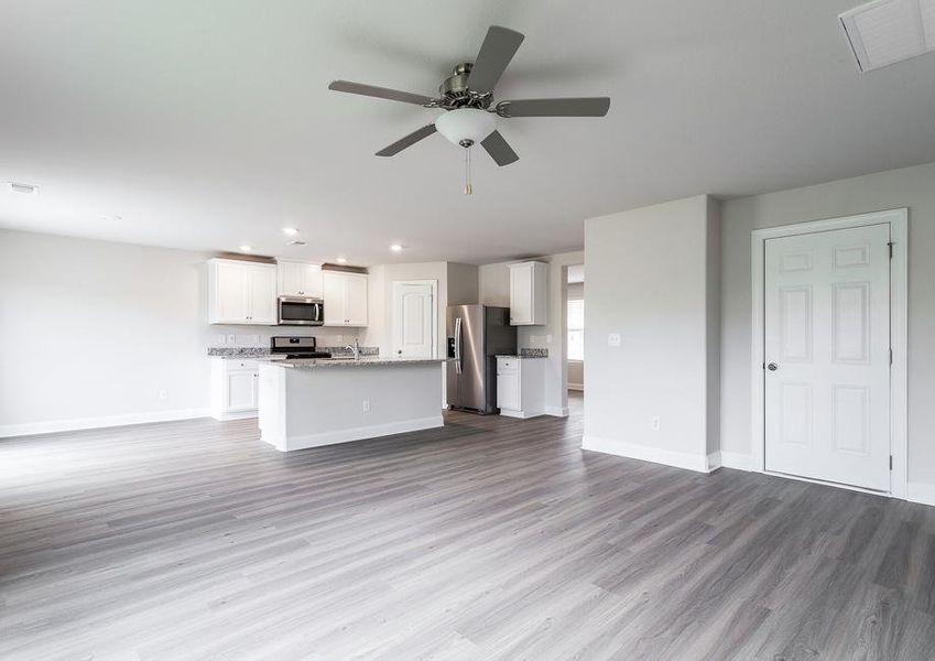 Living room with vinyl flooring and ceiling fan.