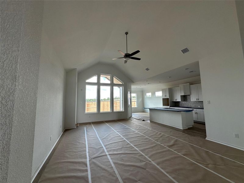 An open-concept living space with a vaulted ceiling and a kitchen island awaits customization.