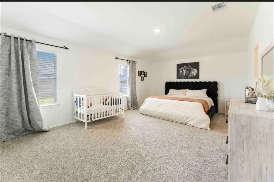Expansive primary bedroom with enough space for a crib, a couch and more. Expansive primary bedroom with enough space for a crib, a couch and more.