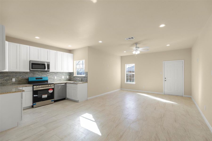This photo shows a modern, two-story house with a light exterior, a gabled roof, and large windows. It features a secure metal fence with a driveway leading to a garage. The property has a small front yard with some greenery. This photo shows a modern, two-story house with a light exterior, a gabled roof, and large windows. It features a secure metal fence with a driveway leading to a garage. The property has a small front yard with some greenery.