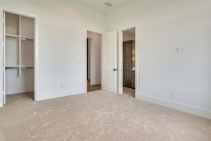 Unfurnished bedroom with visible vents, carpet, a closet, and connected bathroom