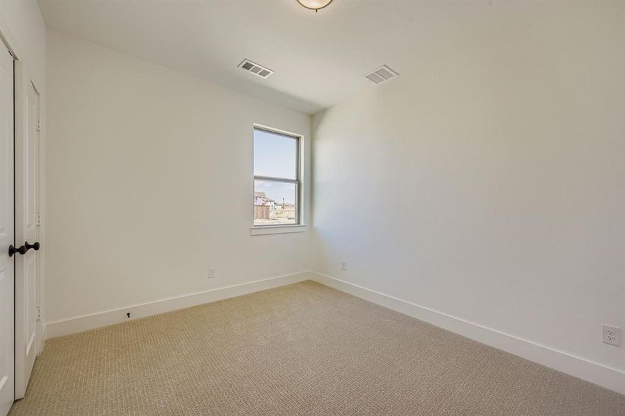 Carpeted spare room featuring baseboards Carpeted spare room featuring baseboards