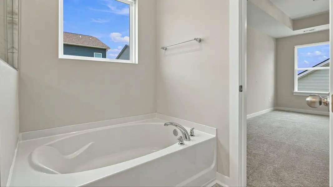 Bathtub with window above next to bathroom entryway Bathtub with window above next to bathroom entryway
