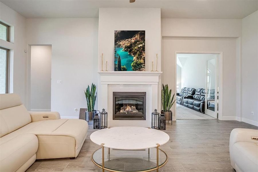 Living area featuring light wood finished floors and a glass covered fireplace Living area featuring light wood finished floors and a glass covered fireplace