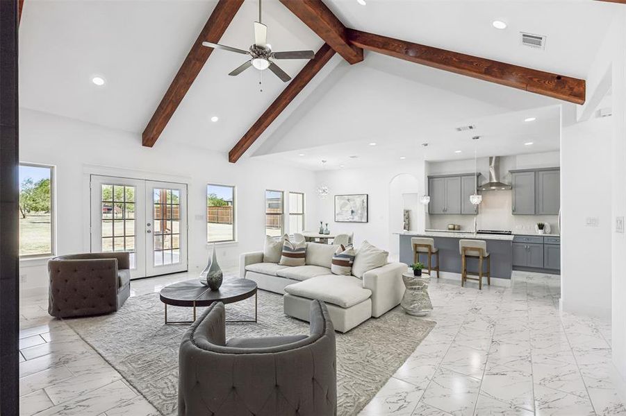 Tiled living room with high vaulted ceiling, french doors, beamed ceiling, and ceiling fan