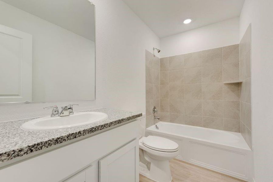 Full bath featuring toilet, recessed lighting, wood finished floors, vanity, and tub / shower combination