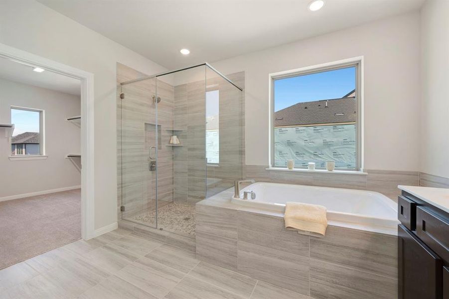Bathroom featuring a garden tub, vanity, a shower stall, healthy amount of natural light, and recessed lighting
