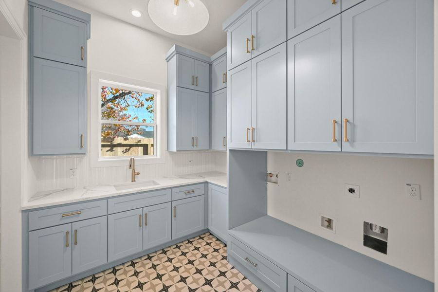 The stunning utility room offers a sink, window, and tons of storage!