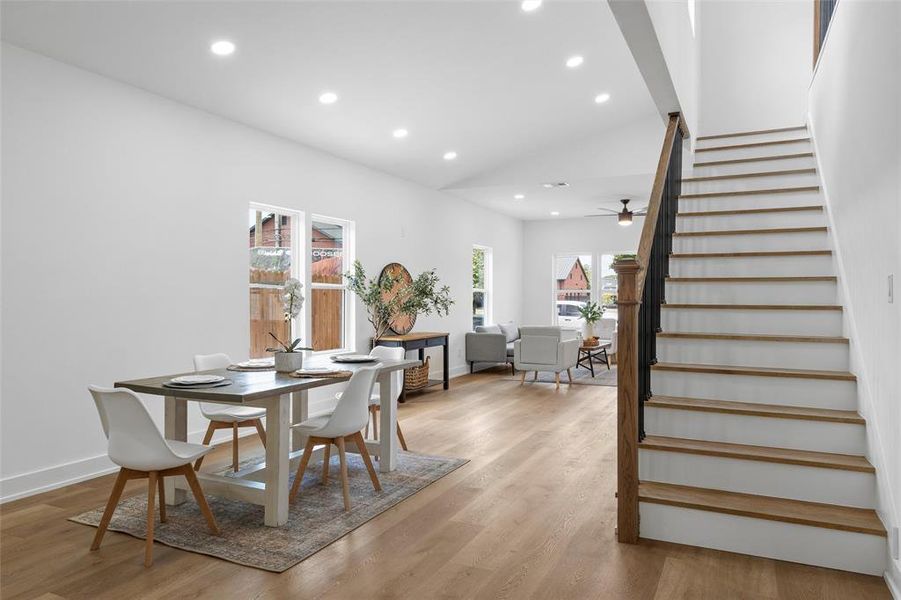 Dining room with stairs, vaulted ceiling, recessed lighting, light wood-style flooring, and ceiling fan Dining room with stairs, vaulted ceiling, recessed lighting, light wood-style flooring, and ceiling fan