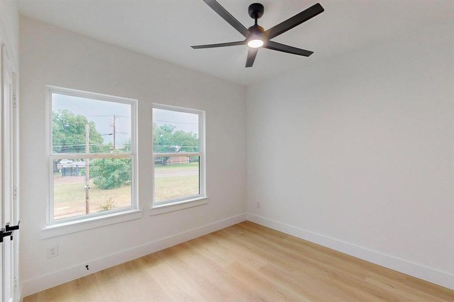 Spare room featuring light wood-style flooring and ceiling fan Spare room featuring light wood-style flooring and ceiling fan