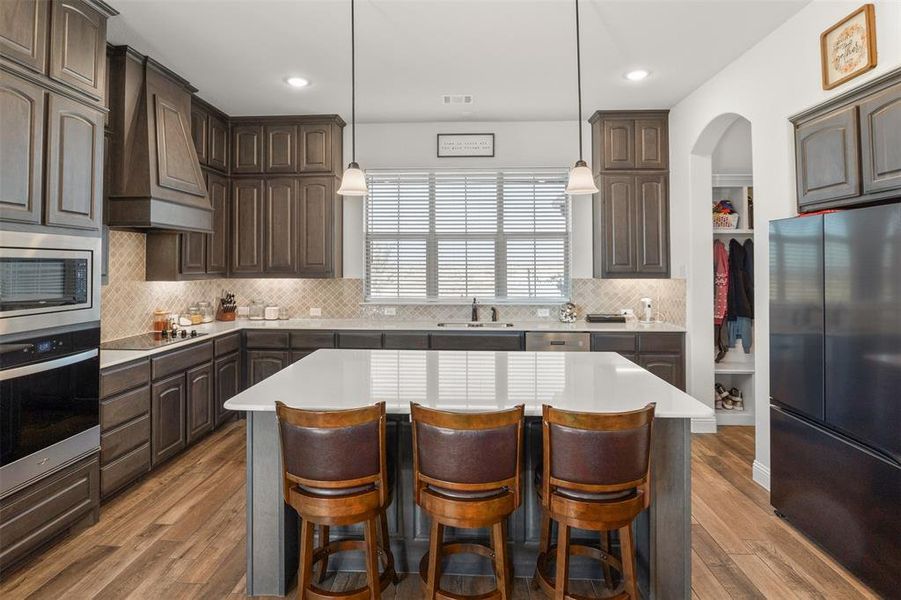 Kitchen featuring a kitchen island, dark brown cabinetry, and stainless steel appliances Kitchen featuring a kitchen island, dark brown cabinetry, and stainless steel appliances