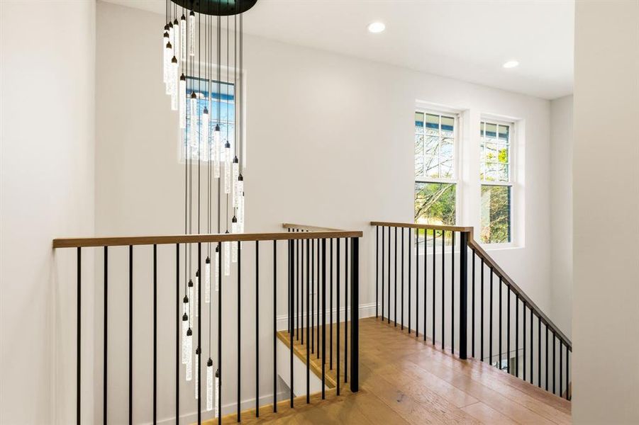 Corridor featuring wood-type flooring, recessed lighting, and an upstairs landing
