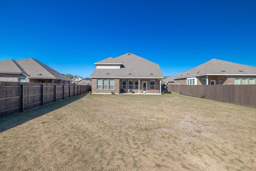 Rear view of property with a patio area, a fenced backyard, and brick siding