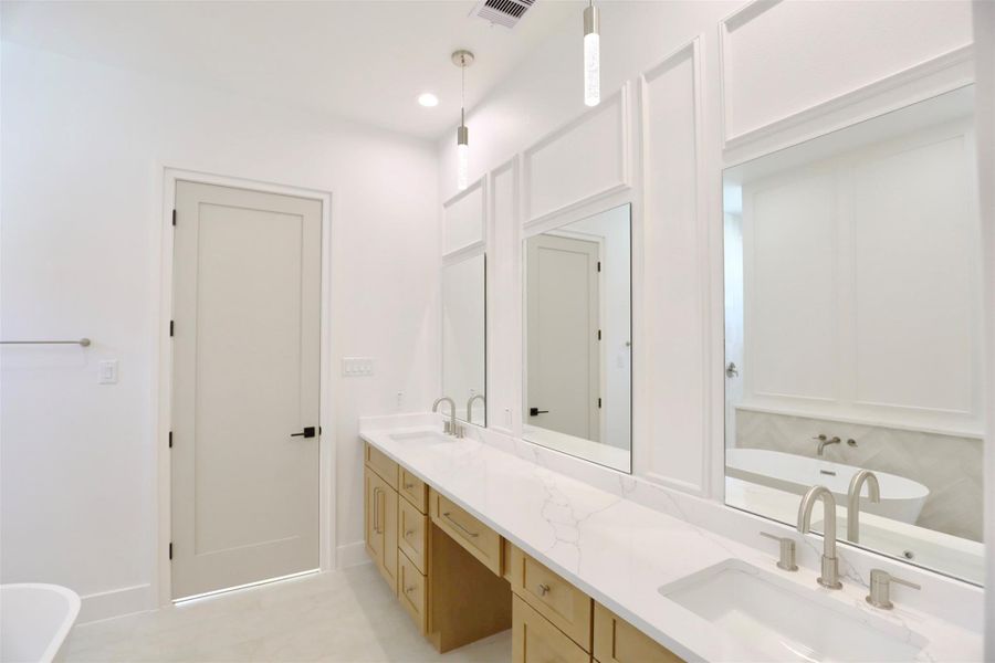 Exquisite wall trim delivers dimension, and refined craftsmanship.The expansive vanity is complemented by three custom-sized mirrors. Exquisite wall trim delivers dimension, and refined craftsmanship.The expansive vanity is complemented by three custom-sized mirrors.