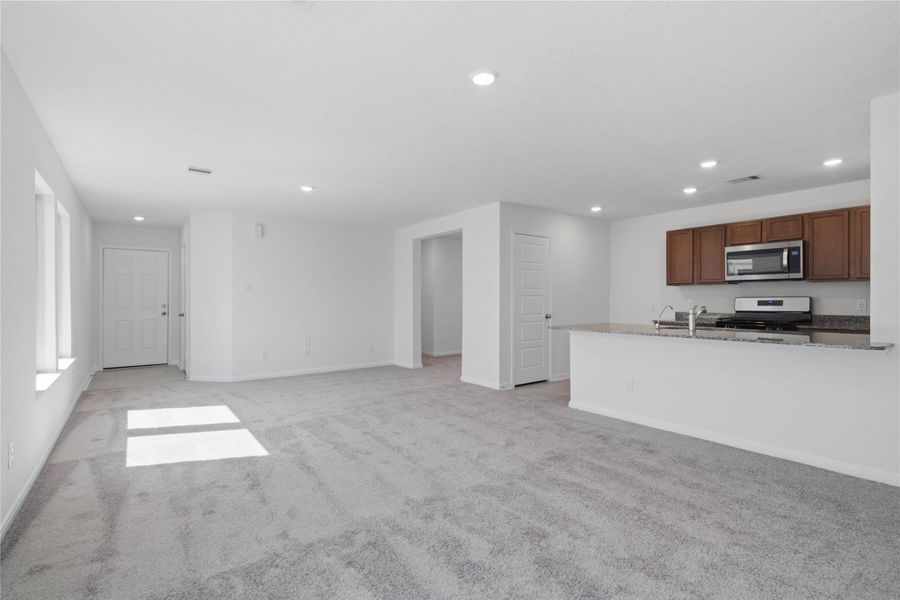 Upon entering this gorgeous home, you find a lovely entryway showcasing custom paint, tile flooring, and recessed lighting that guides you to the open concept living space!