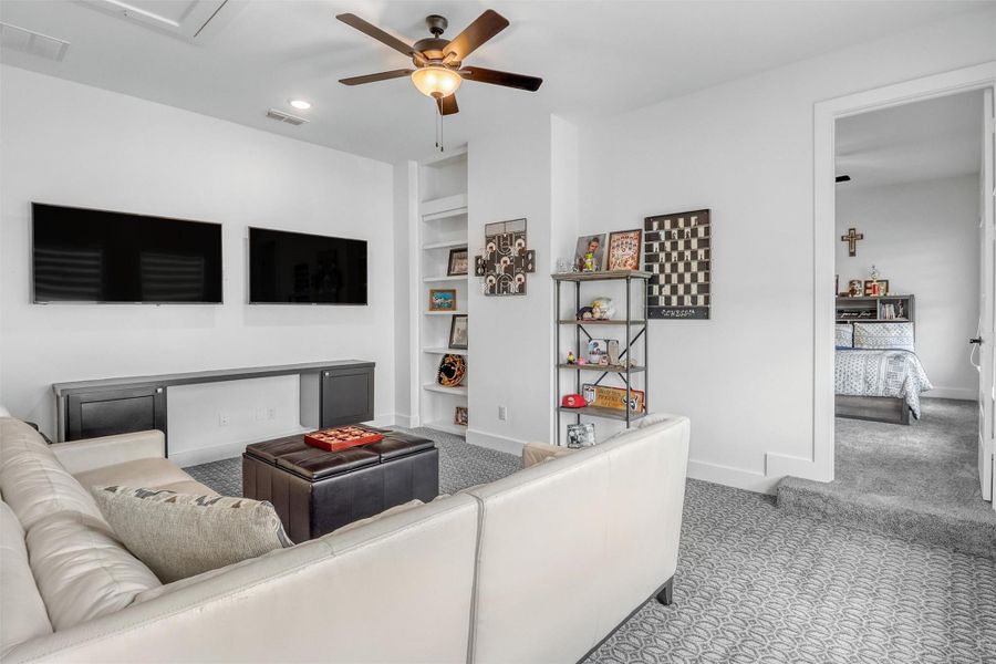 Second game room upstairs has plush carpeting, ceiling fan, and a hidden storage closet behind the bookcase in the corner!