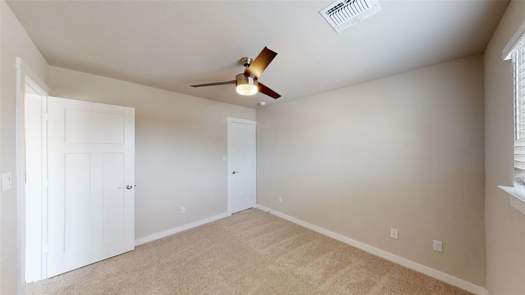 Unfurnished bedroom featuring light colored carpet and ceiling fan