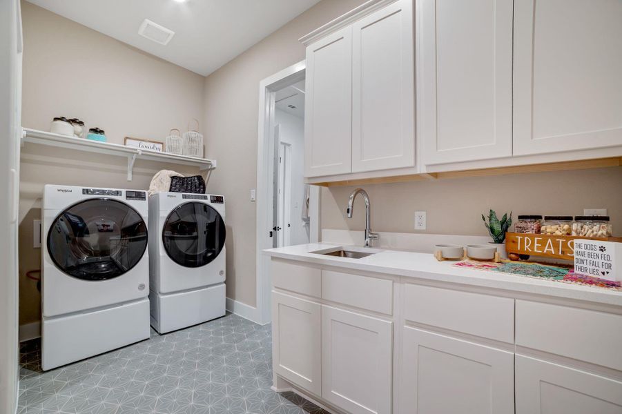 Laundry room featuring separate washer and dryer, cabinet space, and light flooring