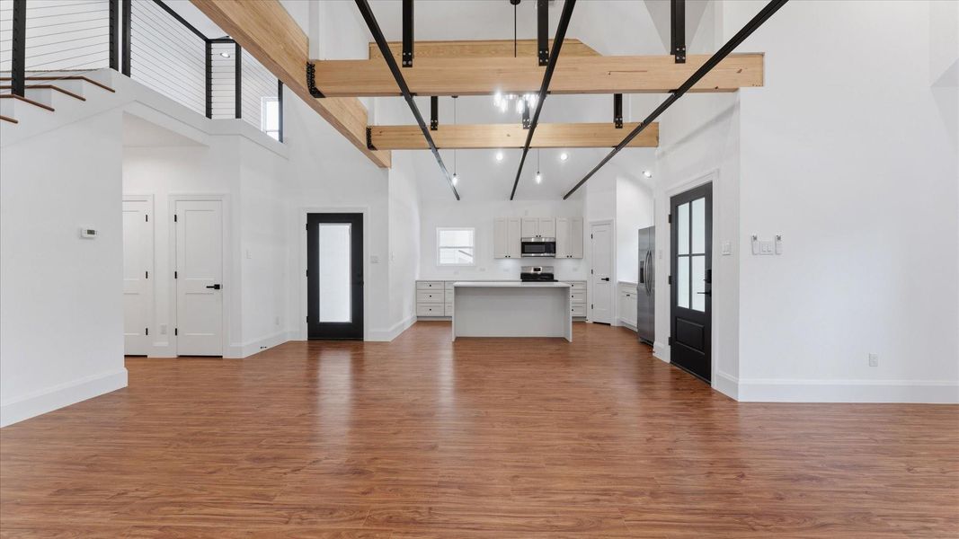Beautiful open space with high ceilings  connecting downstairs living space and kitchen
