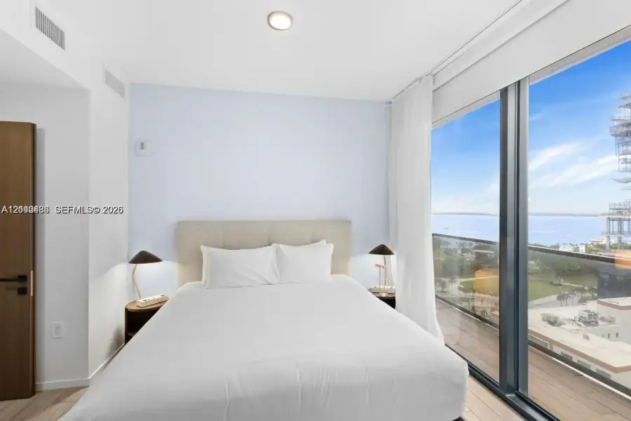 Floor-to-ceiling windows, wood-finish flooring, and access to a private balcony with water scenery Floor-to-ceiling windows, wood-finish flooring, and access to a private balcony with water scenery