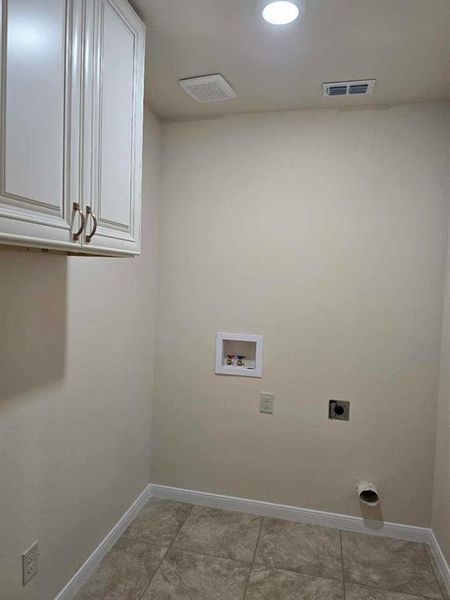 Laundry area featuring electric dryer hookup, cabinet space, and washer hookup Laundry area featuring electric dryer hookup, cabinet space, and washer hookup