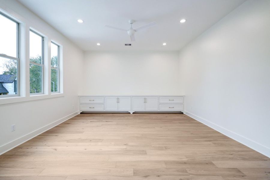 The game room is situated at the heart of the second floor. The abundance of natural light through the windows creates a natural transition on the second floor. Built-in cabinetry offers space for gaming systems, toys and A/V equipment. *Previous Project*
